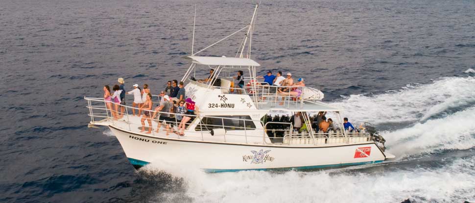 a large boat cruises along the ocean with groups of people aboard