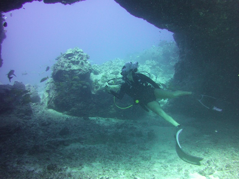 scuba divemaster under arch looking up