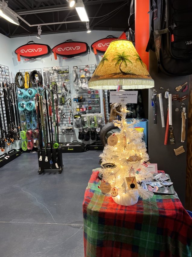 view of nook in dive shop containing spearfishing gear with mermaid lamp in background