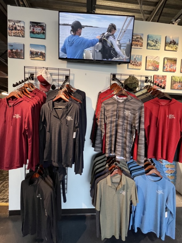 sun shirts on display in a dive shop with logo