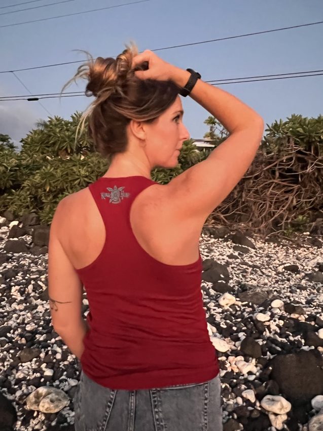 woman in a red tank top with Kona Honu Divers logo on back