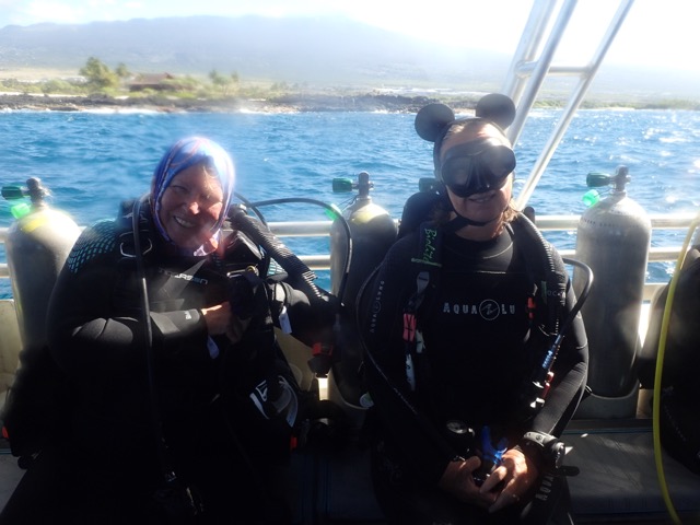 2 divers on a dive boat in dive gear one with Mickey Mouse ears on