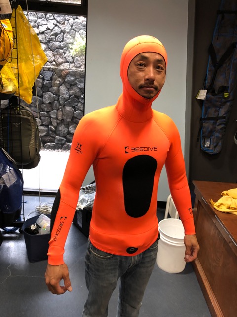 man wearing orange spearfishing wetsuit