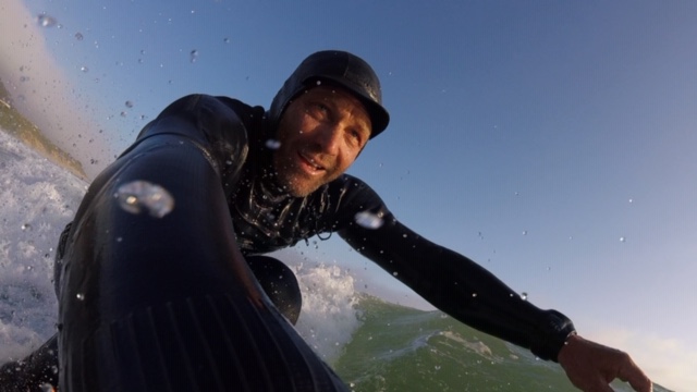 man surfing in heavy wetsuit