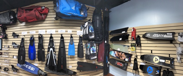 a corner in a dive shop with fins and bags