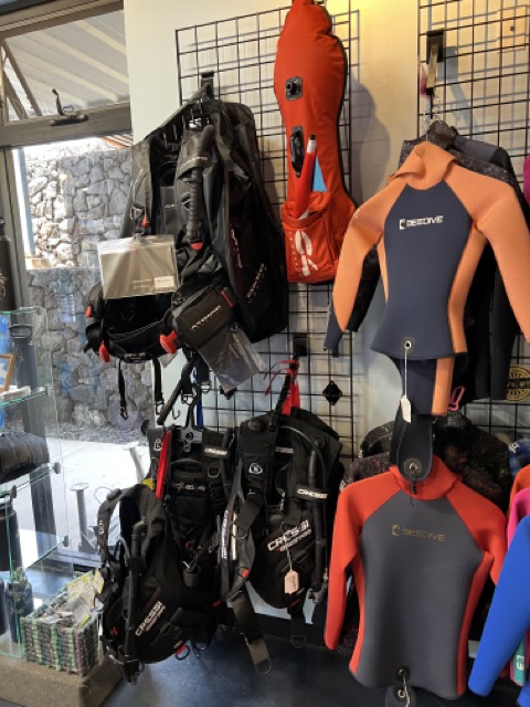 wetsuits and beds on display inside a dive shop