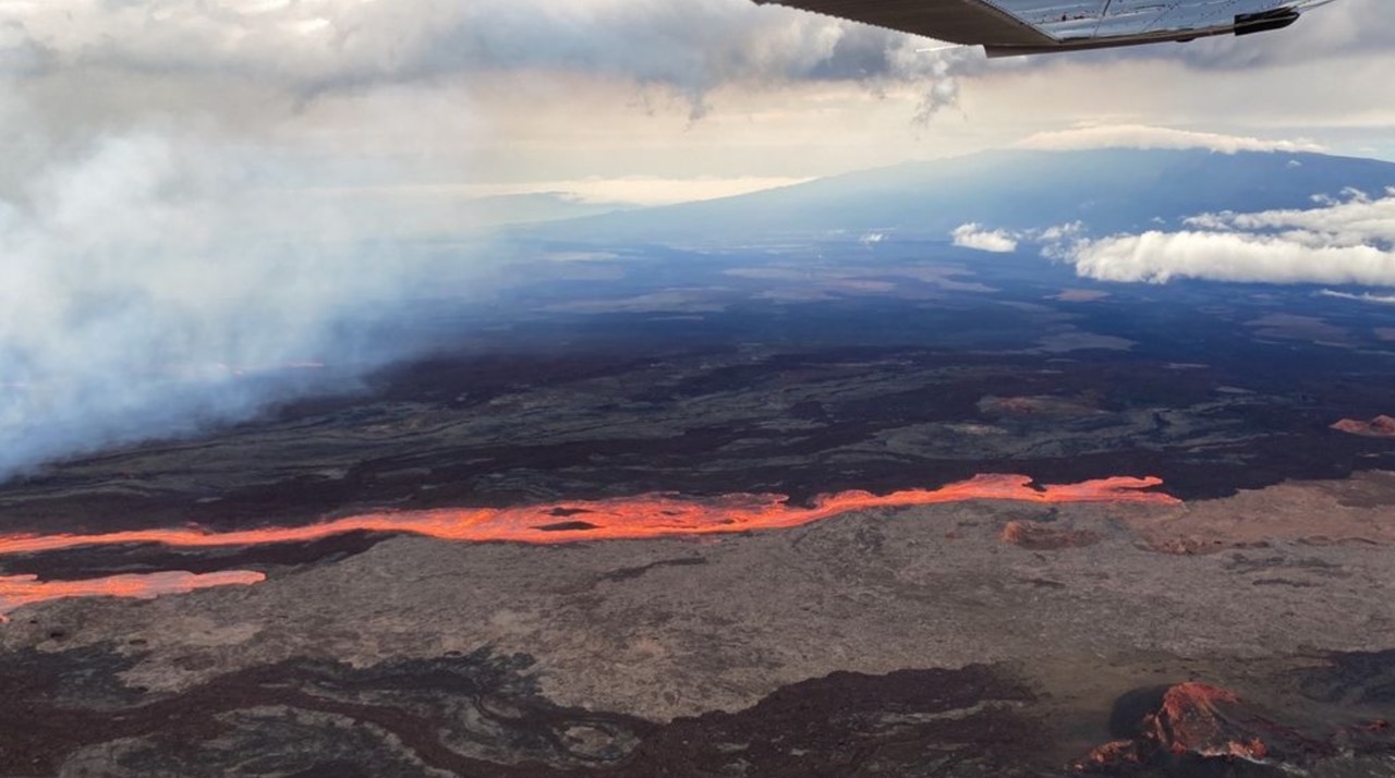 view from the air of lava flowing down the volcano slope