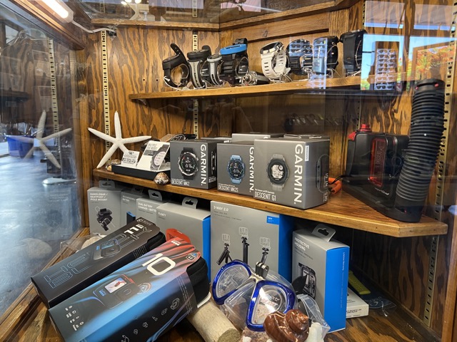 computers and GoPros in a display case inside a dive shop