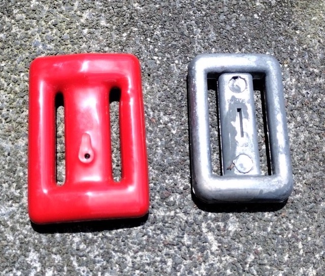 2 lead lace-through dive weights sitting on concrete. one is coated in rubber, the other is raw lead