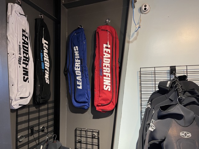 fin bags hanging on a wall in a dive shop