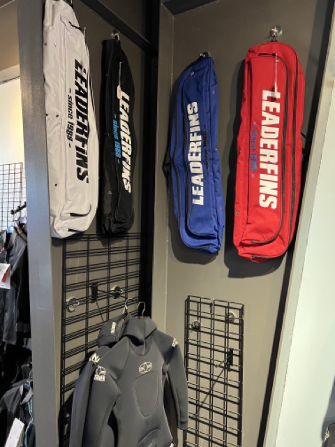 leaderfin bags and wetsuits on display in a dive shop