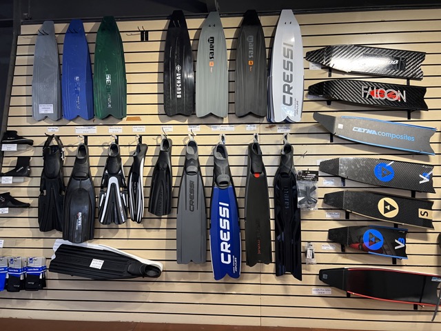 a wall in a dive shop full of dive fins