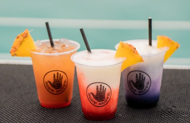 tropical fruits drinks with straws in plastic cups
