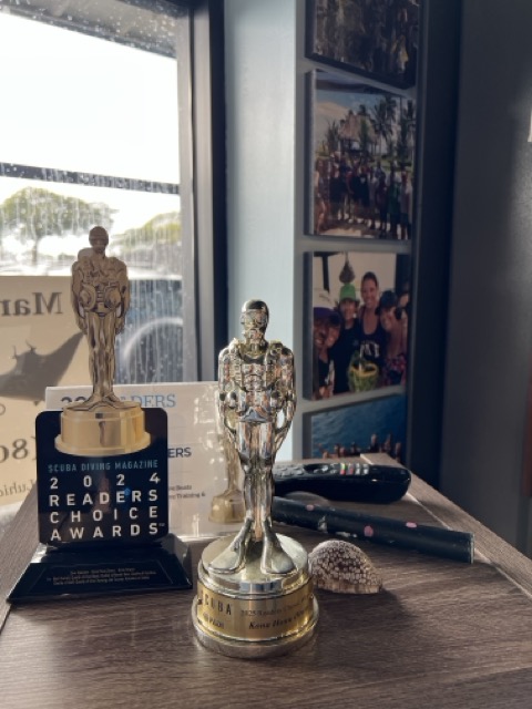 golden Scubie awards sitting on a bookshelf. One says 'Scuba diving magazine 2024 readers choice awards'