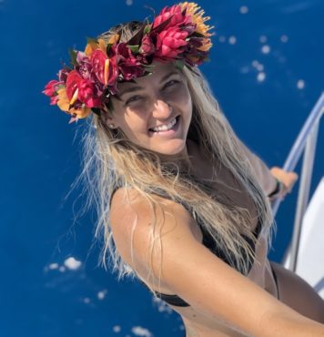 dive boat captain slefie picture. A woman stands against the railing of a boat. The ocean in the background