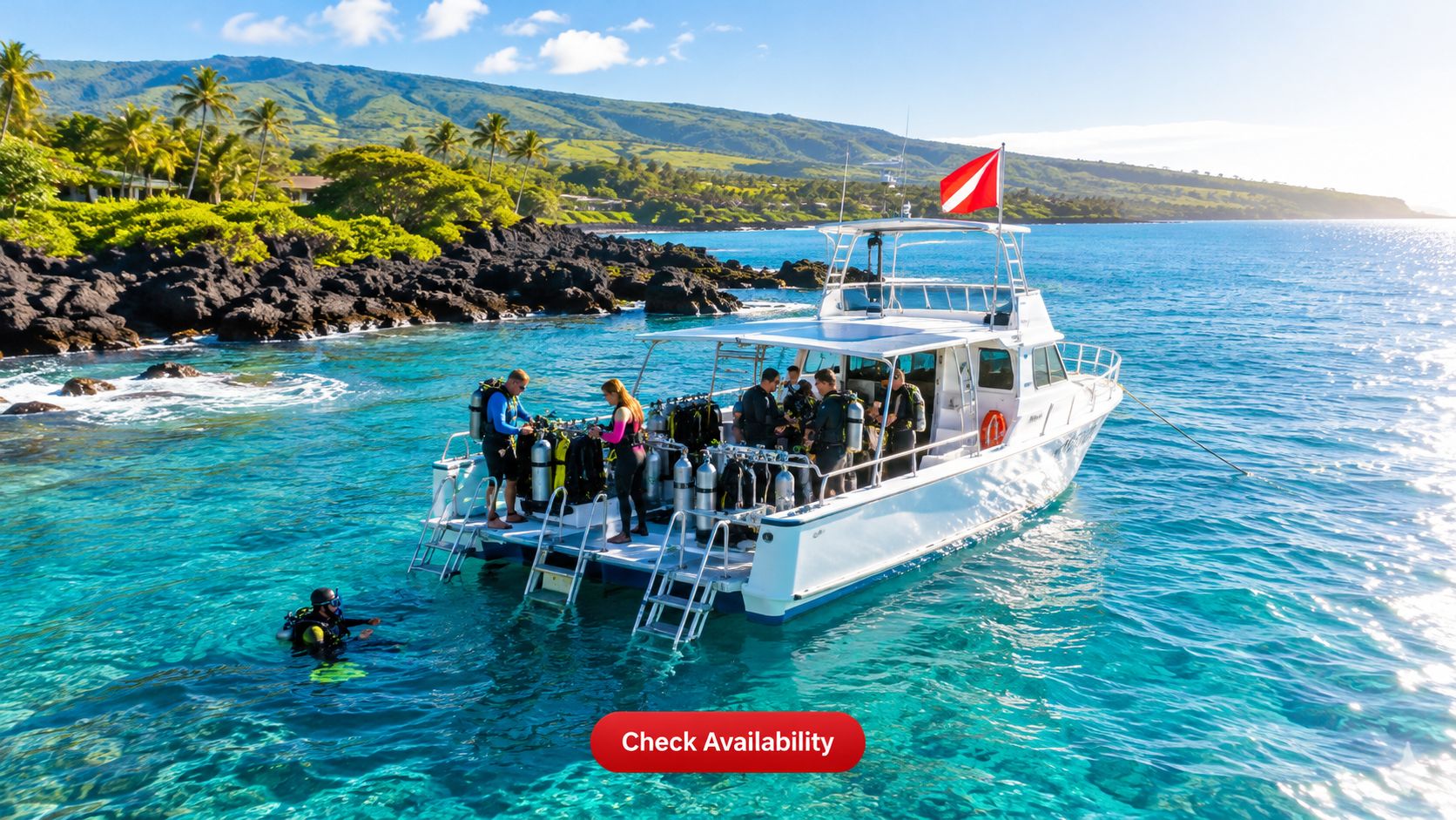 Scuba divers preparing for a dive off a white boat in the turquoise waters of Hawaii.