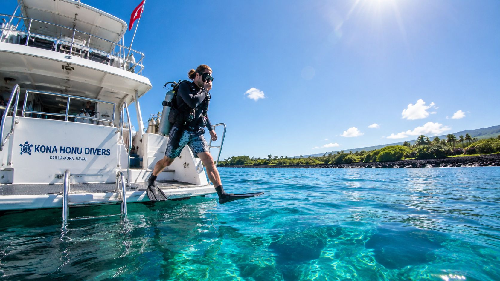 A scuba diver steps off the back of a boat into the clear turquoise waters of Hawaii.