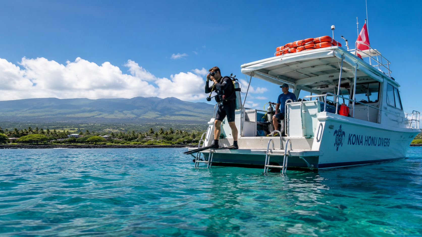 A scuba diver prepares to jump off the back of a boat in the clear tropical waters.